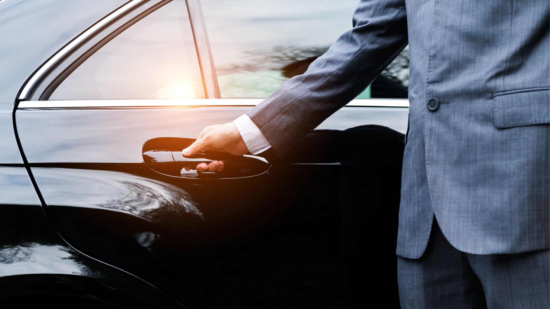 Professional chauffeur opening the car door for a client